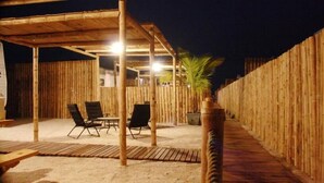 An outdoor seating area with bamboo walls and a covered patio. - Bamboo Paracas Resort (Paracas)