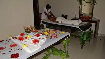 Experience soothing massages in a serene space with a massage table, comfortable bench, and calming ambiance.