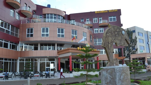 A hotel with a curved facade, multiple balconies, and a prominent entrance.