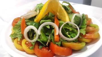 A plate of mixed vegetable salad with lettuce, tomatoes, and onions.