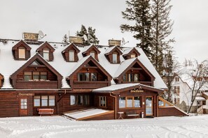 Eine Holzhütte mit mehreren Dachgauben und einer Rampe zum Eingang.