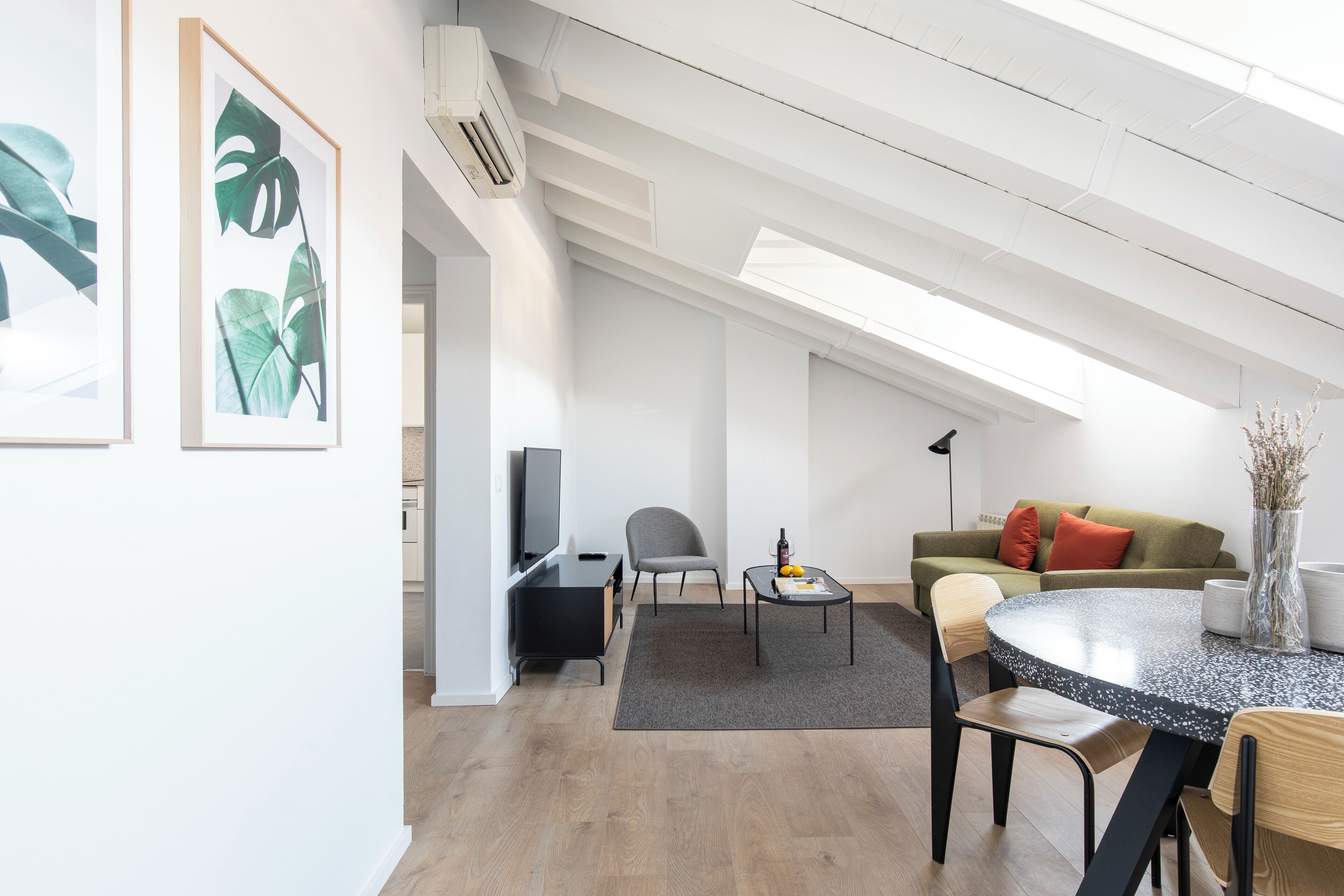 Ein zeitgemäßer Wohnraum mit Essbereich, Sofa und Fernseher.