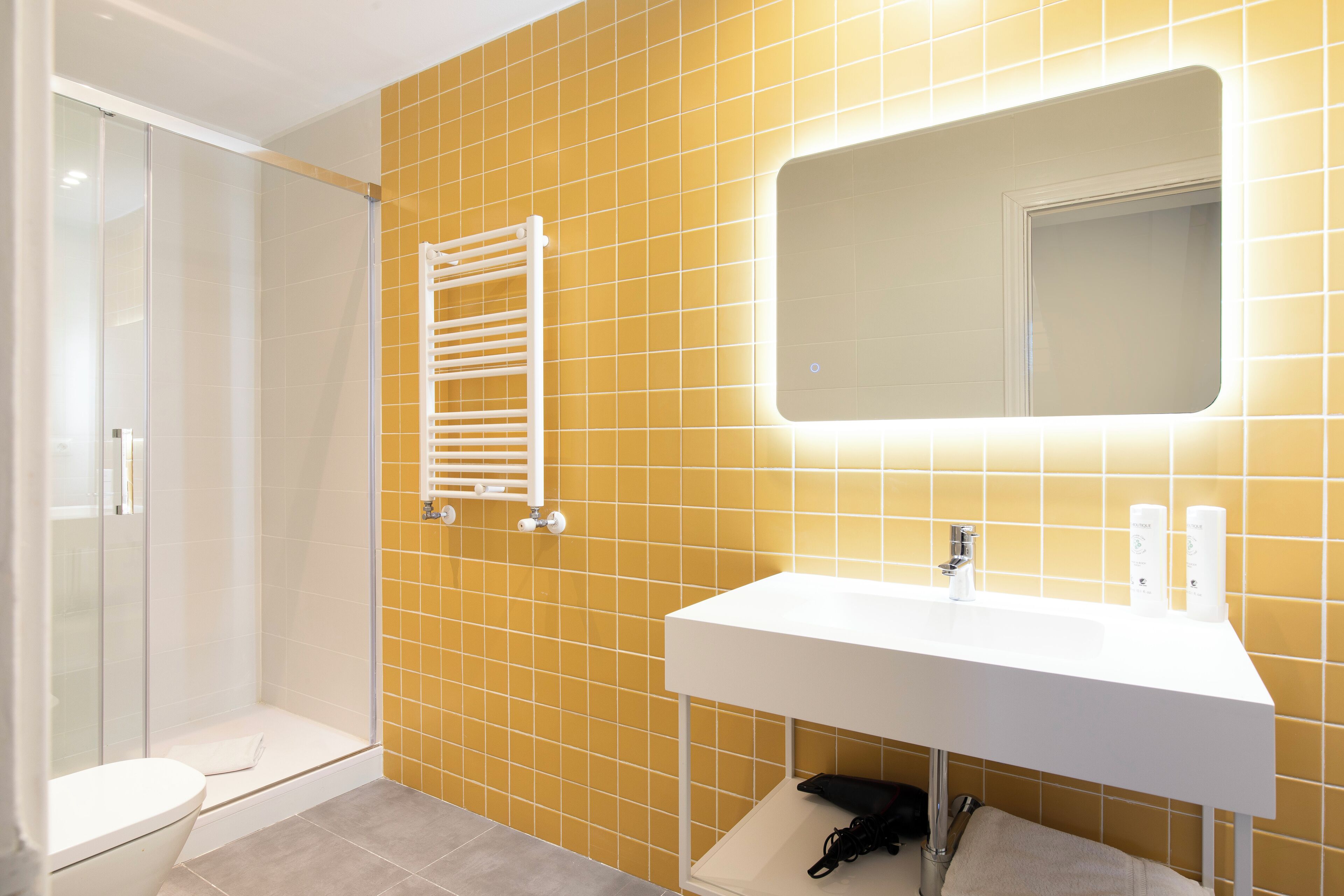 A bathroom with a white sink, a mirror, and a glass-enclosed shower.