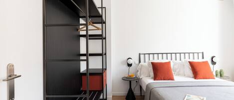 A bedroom with a bunk bed, a bedside table with a lamp, and a small cactus on a nightstand.