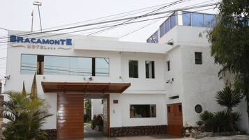 Stunning hotel exterior with a modern design, featuring a prominent entrance and lush garden surroundings.