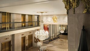 A grand lobby with a chandelier, a balcony with ornate railings, and a statue. - Marriott Vacation Club® at the Mayflower, Washington, D.C. (Washington)