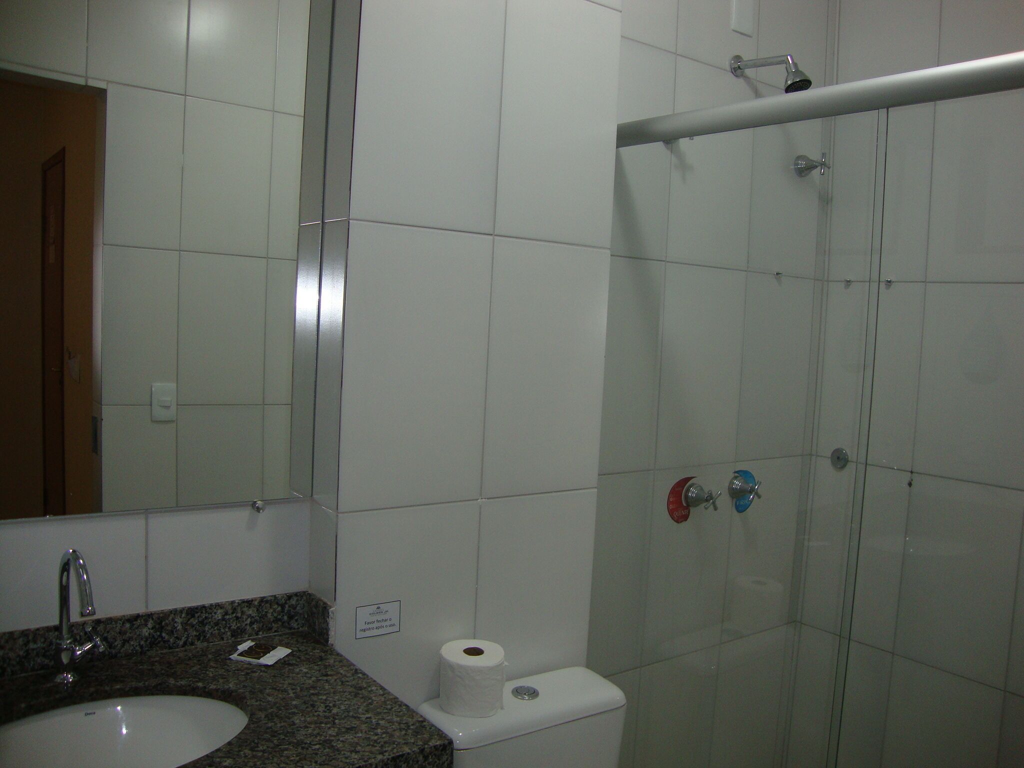 A bathroom with a sink, mirror, toilet, and shower.