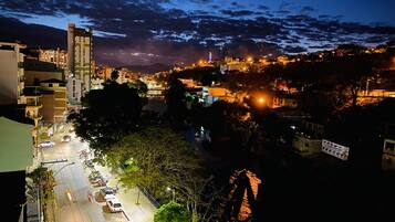 Un paisaje urbano nocturno con edificios, un río y un puente.
