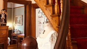 A wooden spiral staircase with a red carpeted landing area. - Evangeline's Tower Bed & Breakfast (Parrsboro)