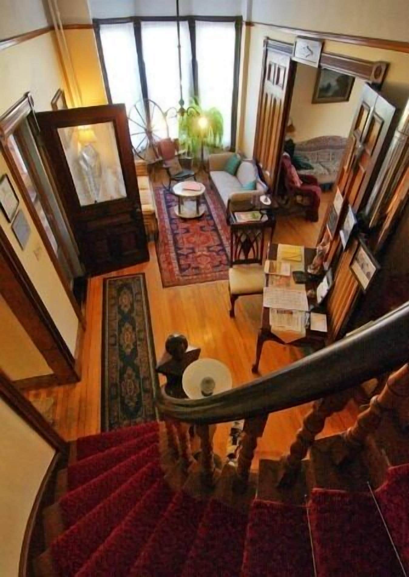 Escales que condueixen a un espai de estar amb un sofà, una taula petita i una catifes.