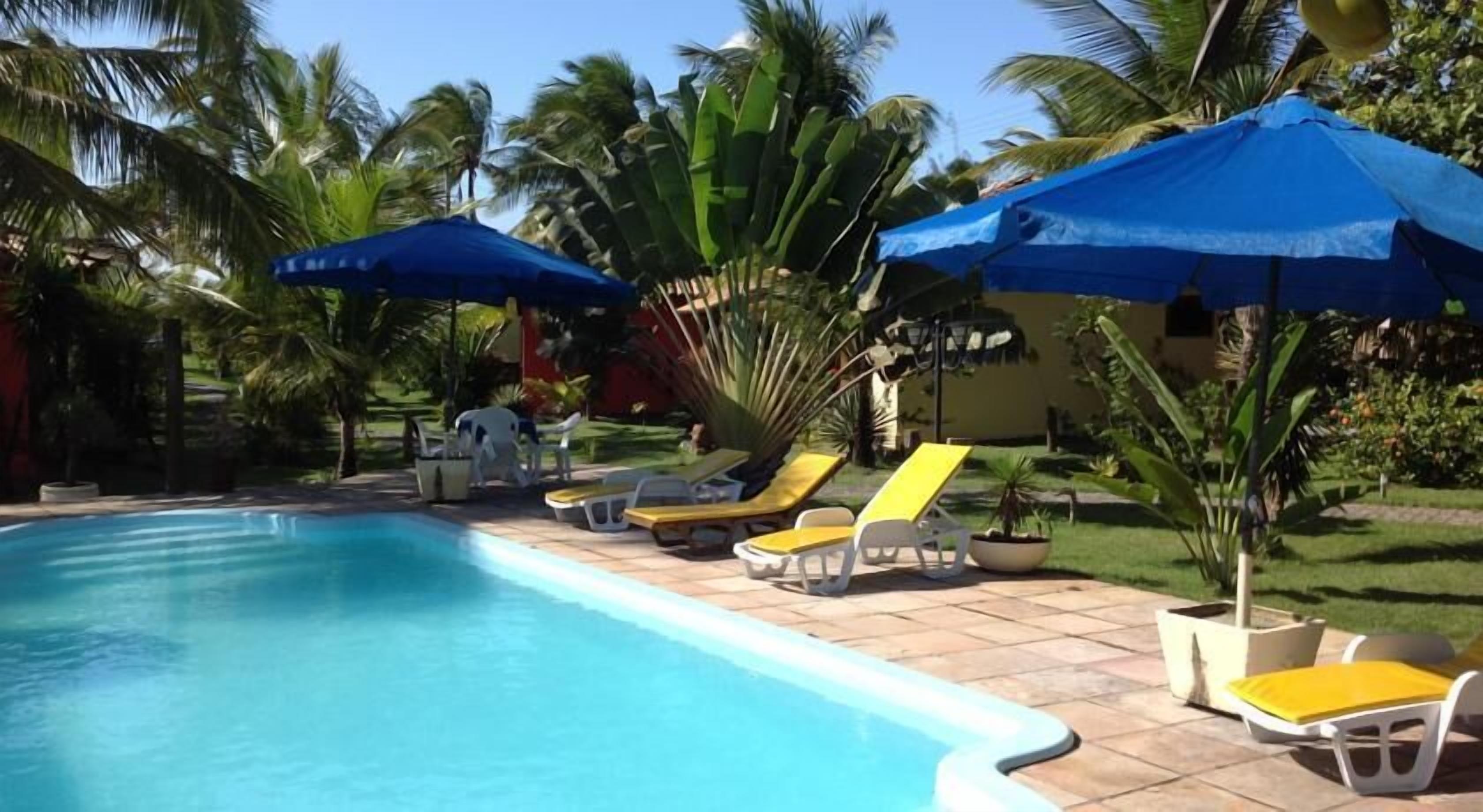 A swimming pool with lounge chairs and umbrellas.