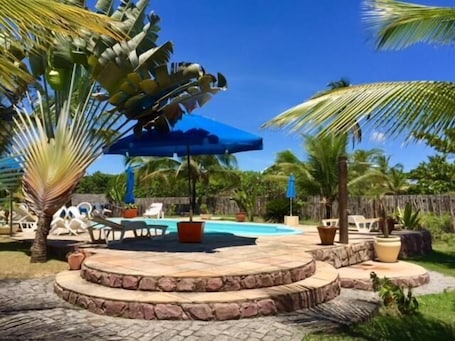 Una piscina al aire libre, sillones reclinables de piscina