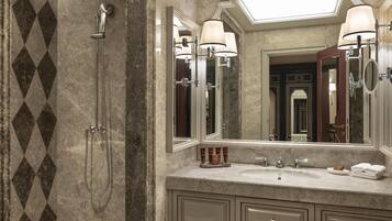 A bathroom with a shower, a sink, and a large mirror.