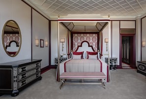 A hotel room with a large bed, a dresser, a mirror, and a decorative wall. - Ciragan Palace Kempinski (Istanbul)