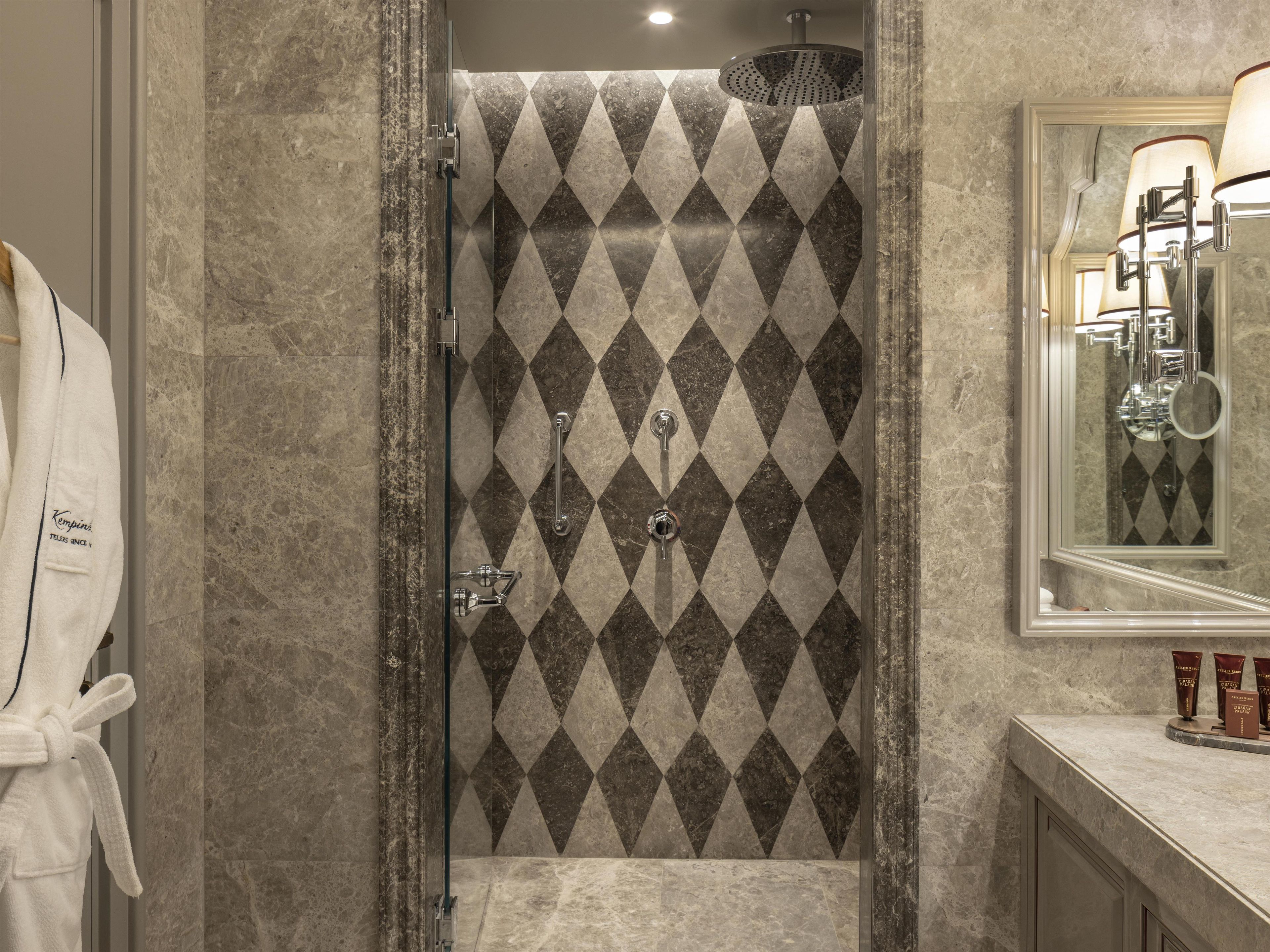 A bathroom with a shower, a towel rack, and a mirror.
