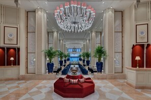 A spacious lobby with a grand chandelier, a red sofa, and a checkered floor. - Ciragan Palace Kempinski (Istanbul)