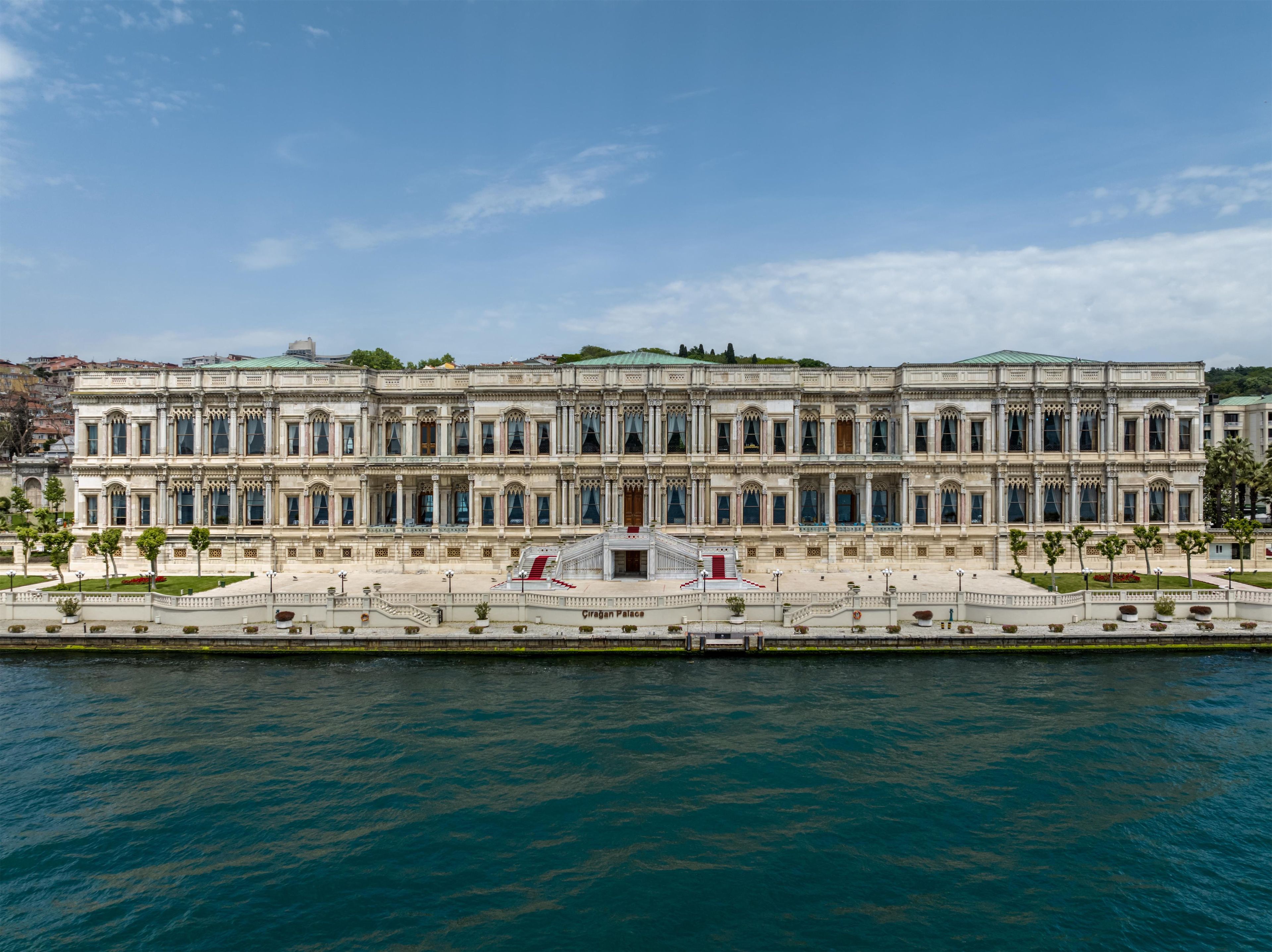 A large, historic building with a symmetrical facade, a central entrance, and a waterfront view.