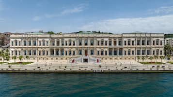 A large, historic building with a symmetrical facade, a central entrance, and a waterfront view.