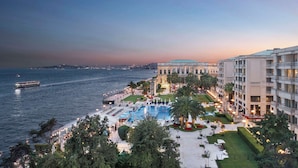 Un resort con una piscina grande, vista al mar y un edificio con cúpula.