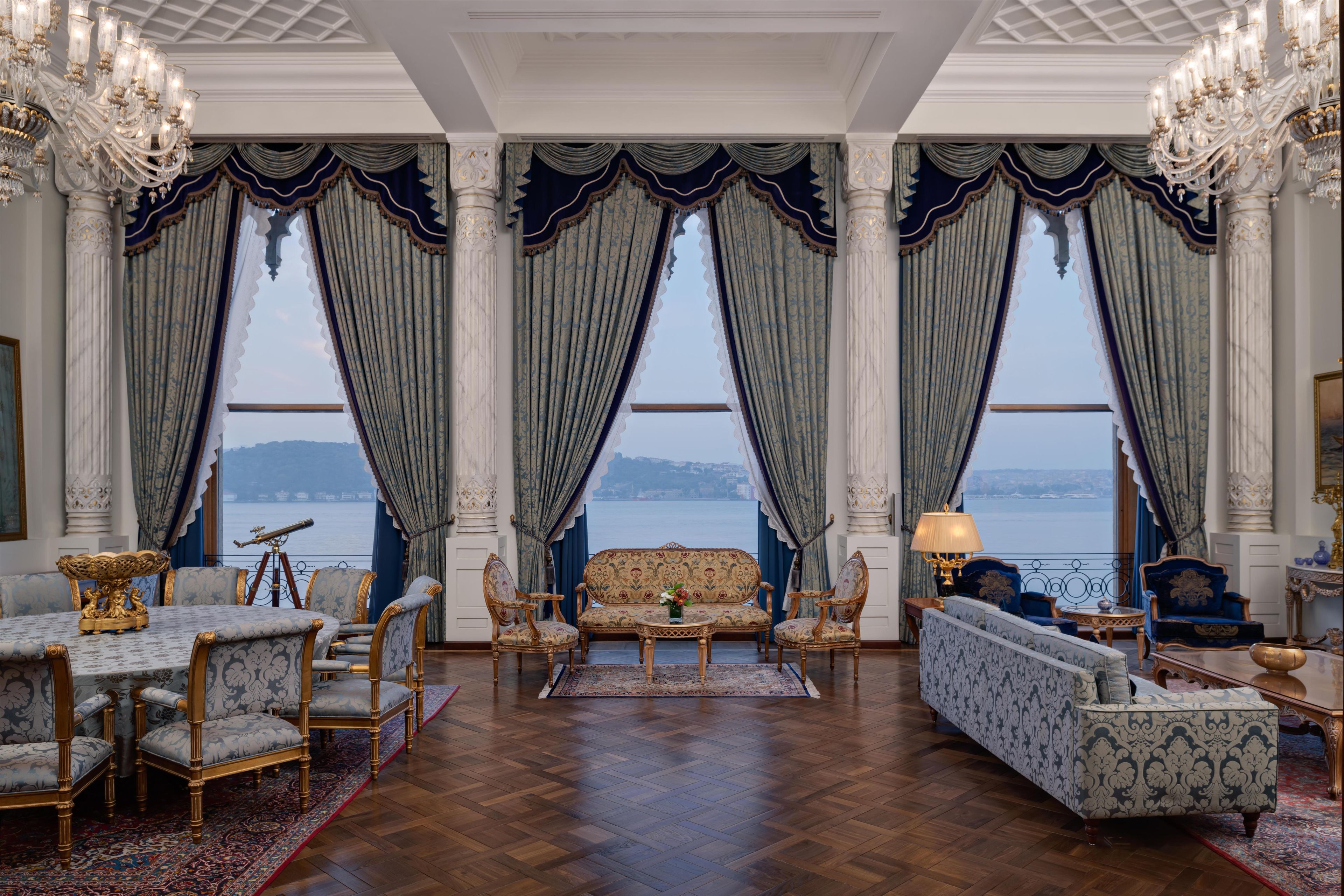 A luxurious room with a large window, elegant furniture, and a view of a body of water.