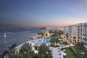 Un resort con piscina, asientos al aire libre y vistas al mar.