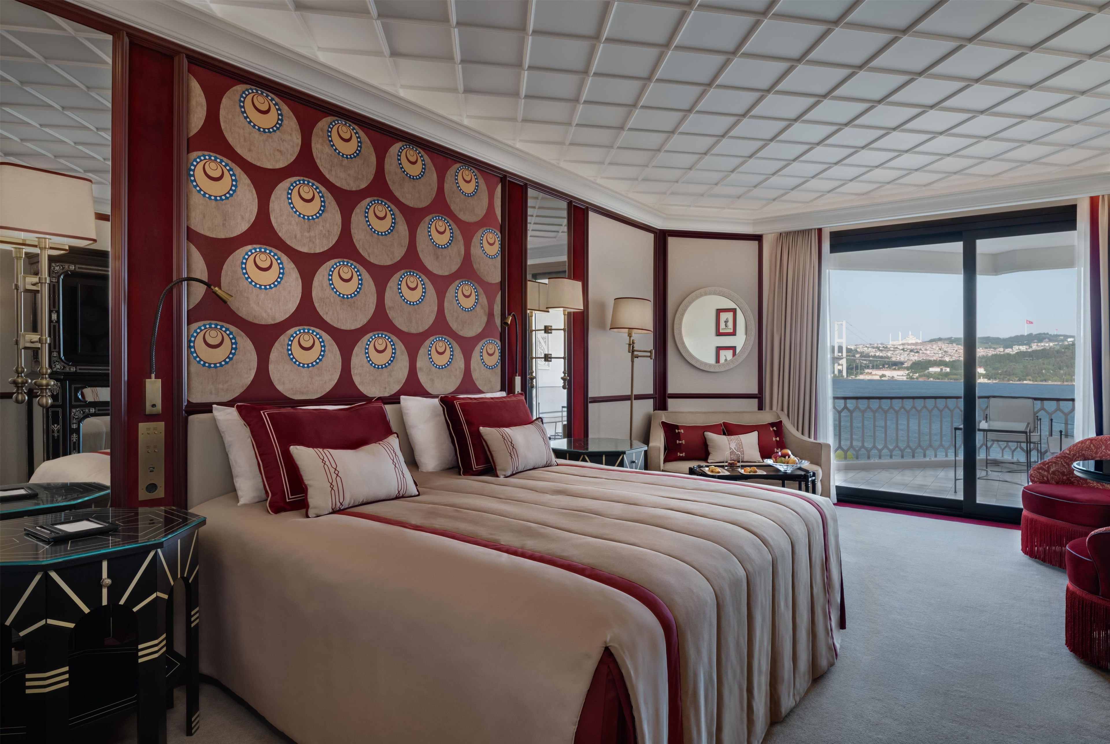 A hotel room with a large bed, a desk, a chair, and a view of a bridge.