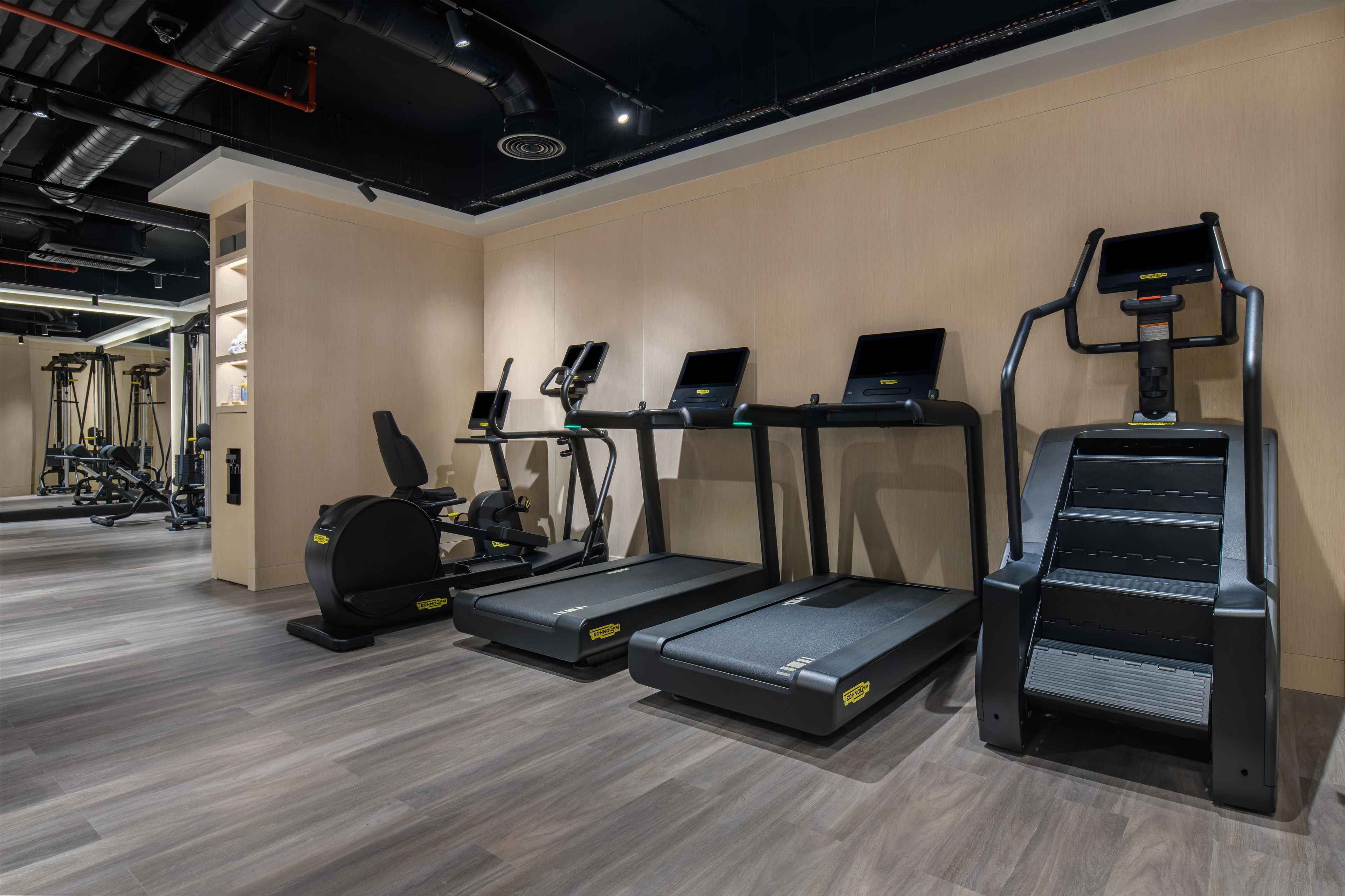 A gym with treadmills, elliptical machines, and a stair climber.