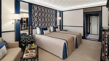 A hotel room with a large bed, a sitting area, a dining table, and a decorative mirror.