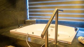 A modern bathroom with a bathtub, a shower area, and a bench.