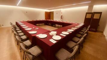 Un salón de conferencias con una larga mesa, sillas y un extintor.
