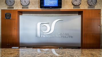 A reception desk with clocks displaying times for Mexico City, New York, London, and Tokyo.