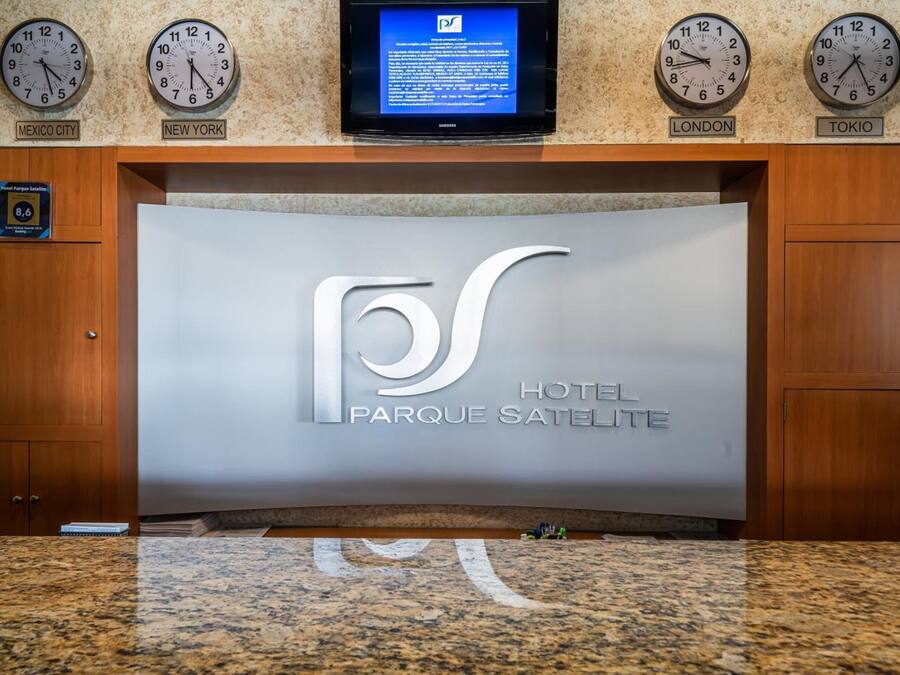 A reception desk with clocks displaying times for Mexico City, New York, London, and Tokyo.