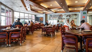 A restaurant with wooden tables and chairs, large windows, and a modern ceiling design. - Hotel Parque Satelite (Tlalnepantla de Baz)