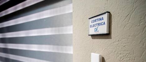 A wall-mounted sign for Cortina Electricia and a thermostat.
