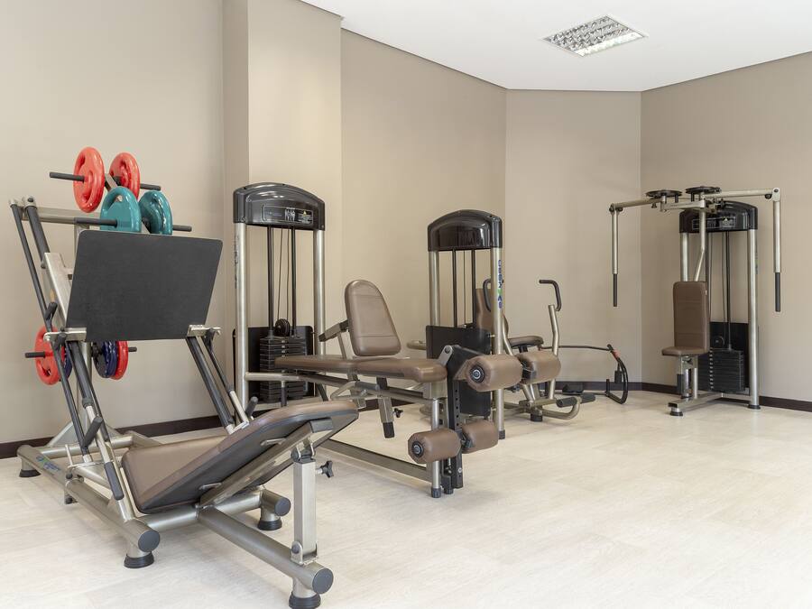 Ein Fitnessstudio mit verschiedenen Trainingsgeräten, darunter Gewichte und Cardiogeräte.