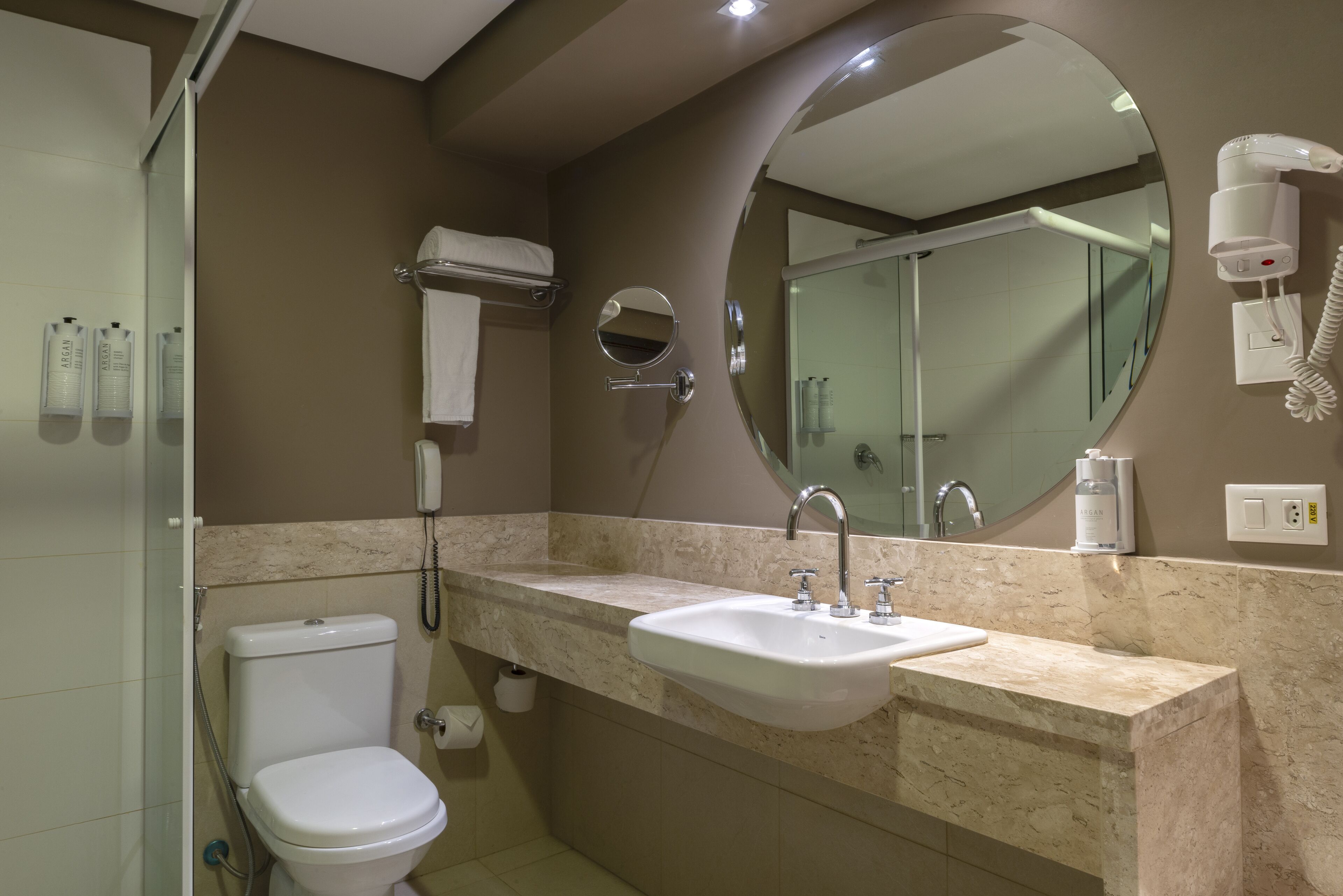 Une salle de bain avec des toilettes, un lavabo et un miroir.