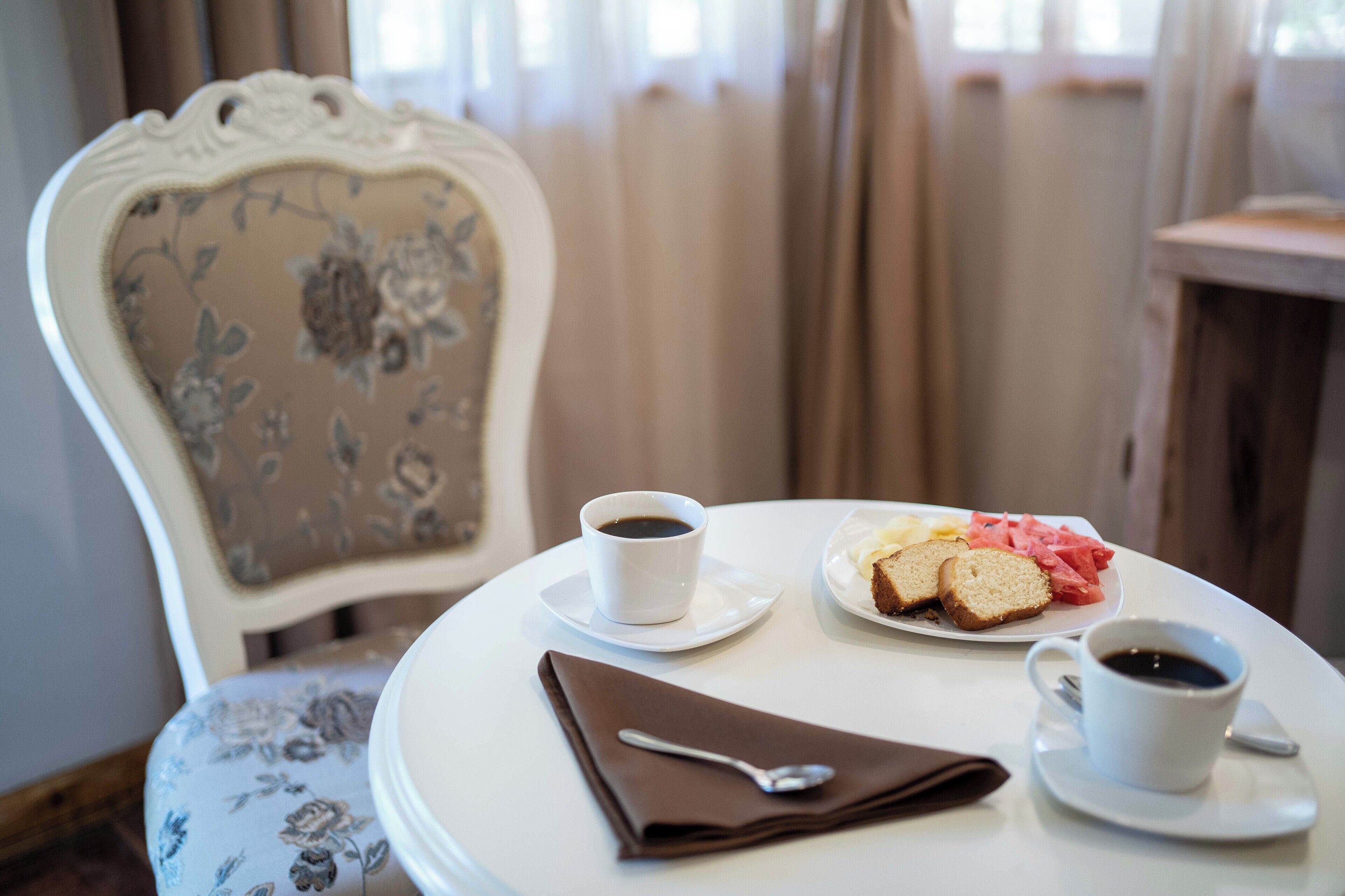 Una mesa de comedor con un plato de comida y dos tazas de café.