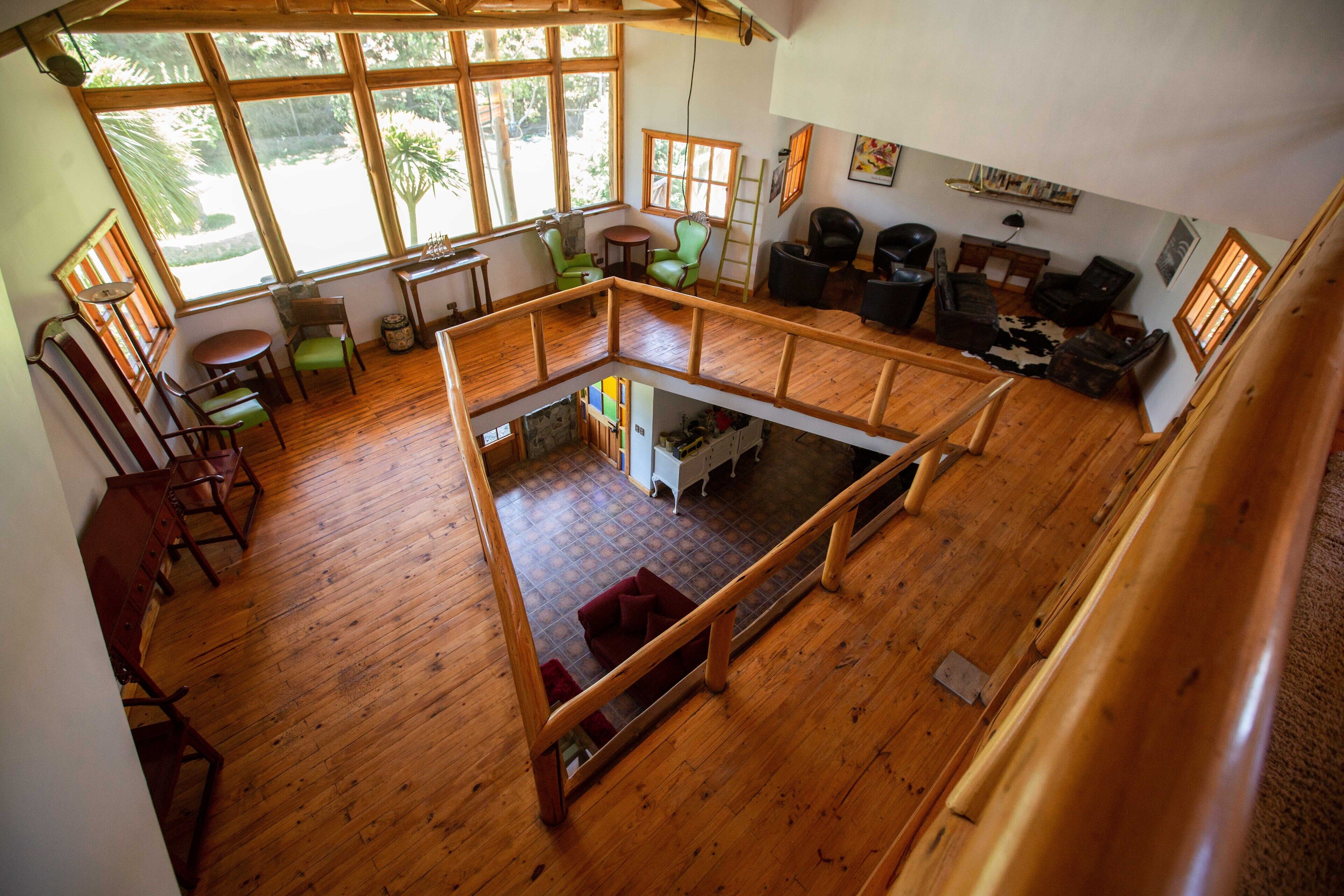 A spacious loft with wooden floors, large windows, and a mezzanine level.
