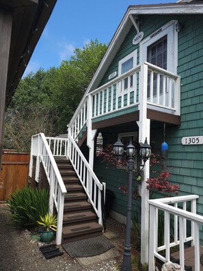 A two-story building with a white staircase leading to a balcony.