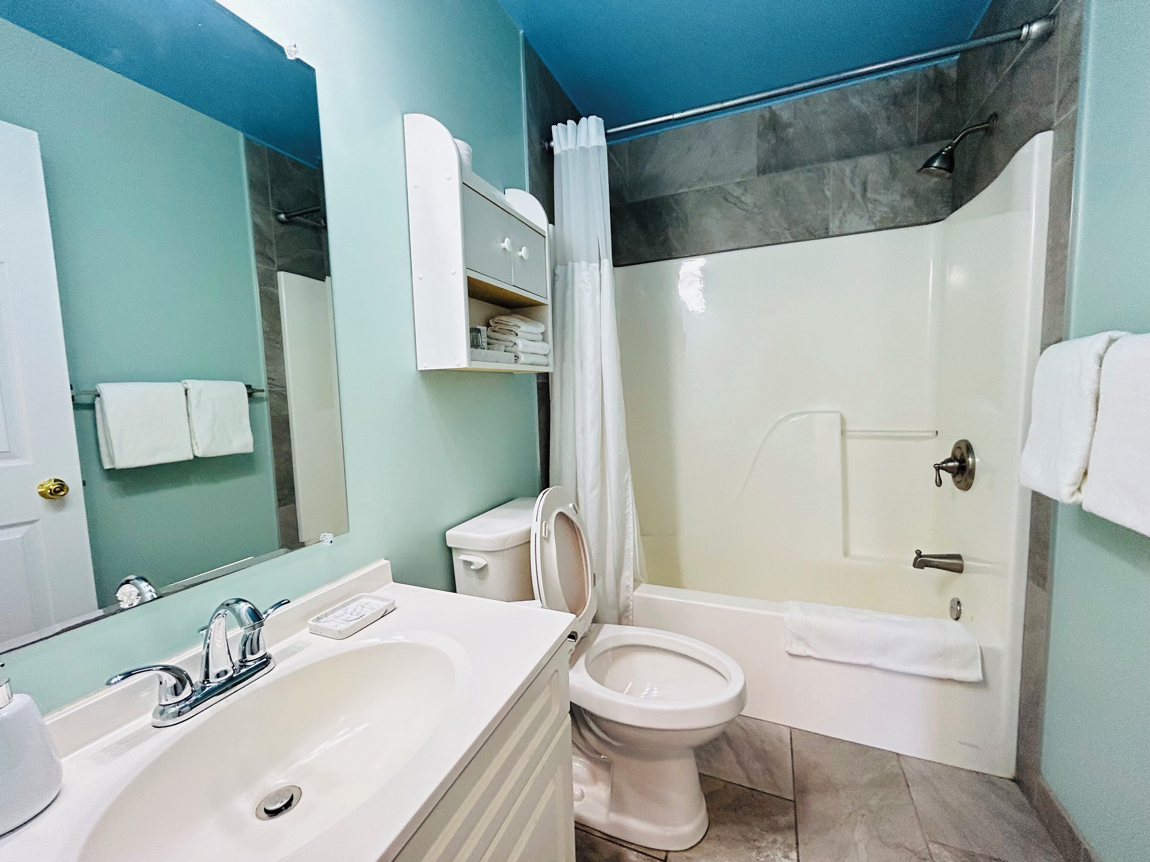 A bathroom with a sink, toilet, and shower.