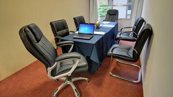 A conference room with a table, chairs, a laptop, and a globe.