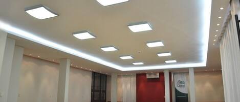 Una habitación amplia con techo alto, iluminación empotrada y una pared de acento roja.