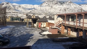 A hotel with a Coca-Cola sign, a staircase, and a view of snow-covered mountains. - Rider's Inn (Kamloops)