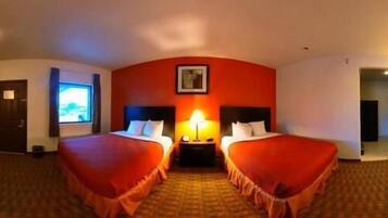 A hotel room with two beds, a desk, a chair, and a television.