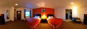 A hotel room with two beds, a desk, a chair, and a television.