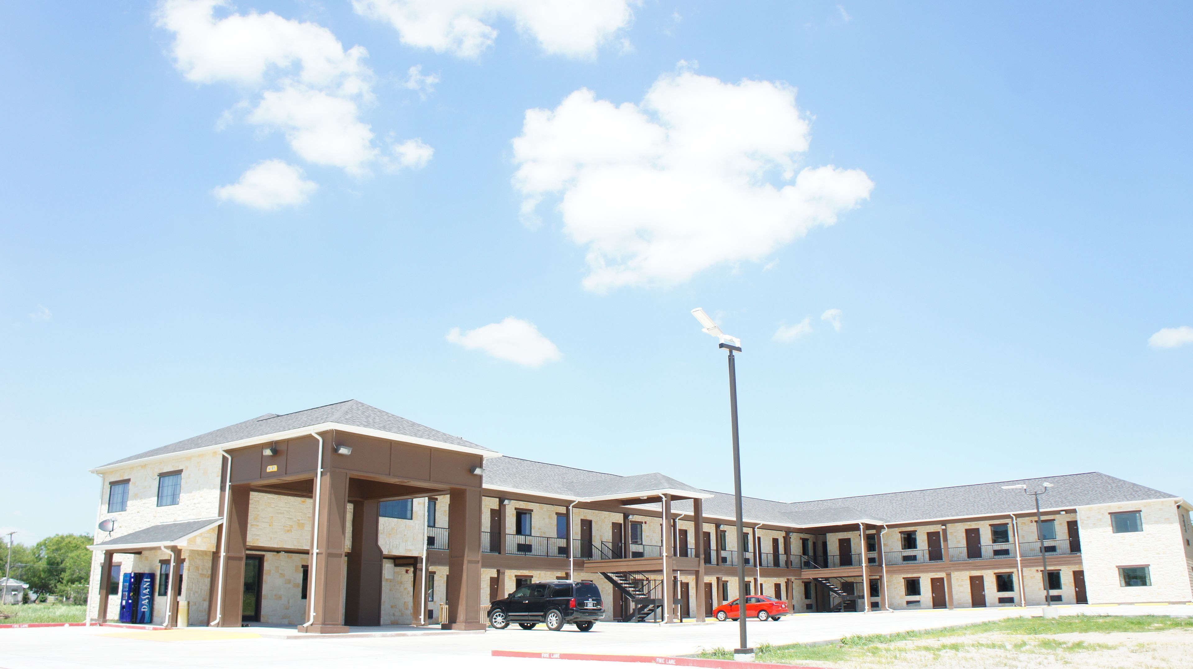 A multi-story building with a covered entrance and a fire lane.