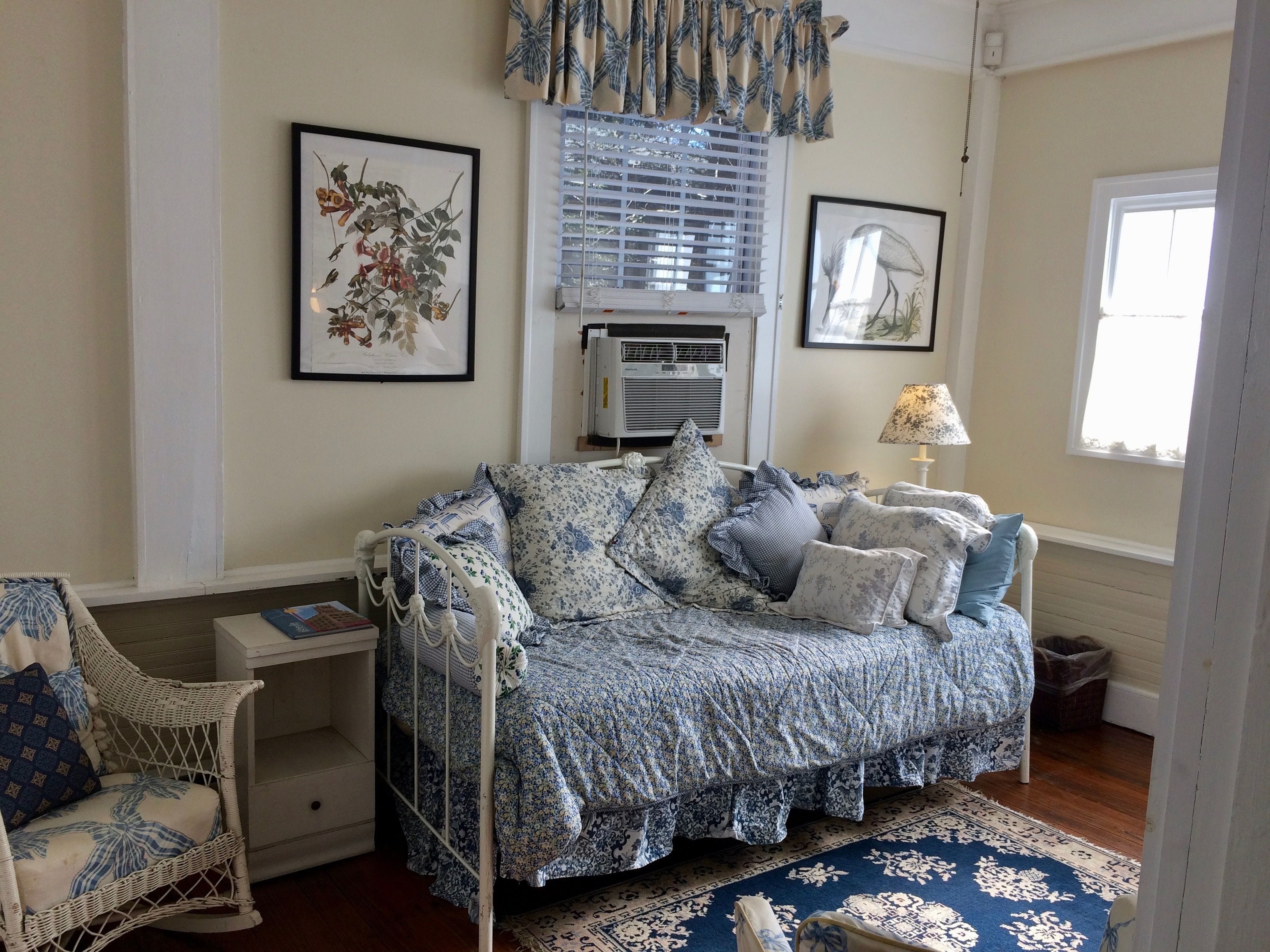 Un dormitorio acogedor con una cama, una silla y una mesita de noche.