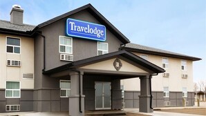 A Travelodge hotel with a modern facade, a covered entrance, and a clear sky. - Travelodge by Wyndham Kindersley (Kindersley)