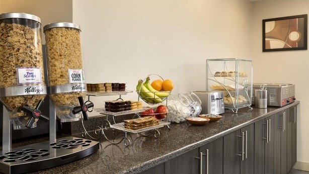 A buffet area with various food options including cereal, fruits, and desserts. - Travelodge by Wyndham Kindersley (Kindersley)