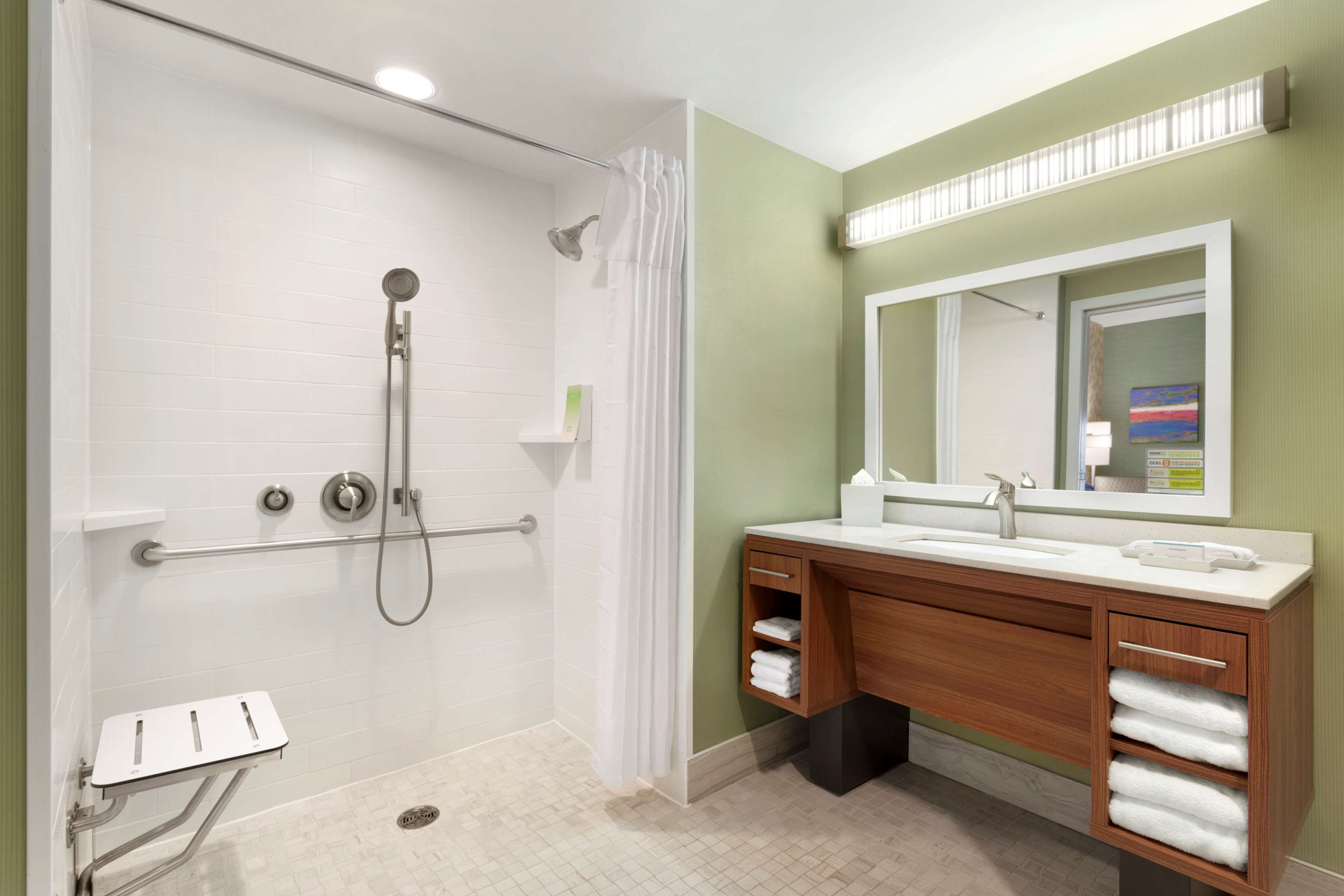 A modern bathroom with a walk-in shower, a vanity with a mirror, and a towel rack.